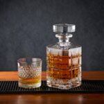 A stylish display of a crystal whisky decanter and glass on a wooden bar top, perfect for alcohol collections.